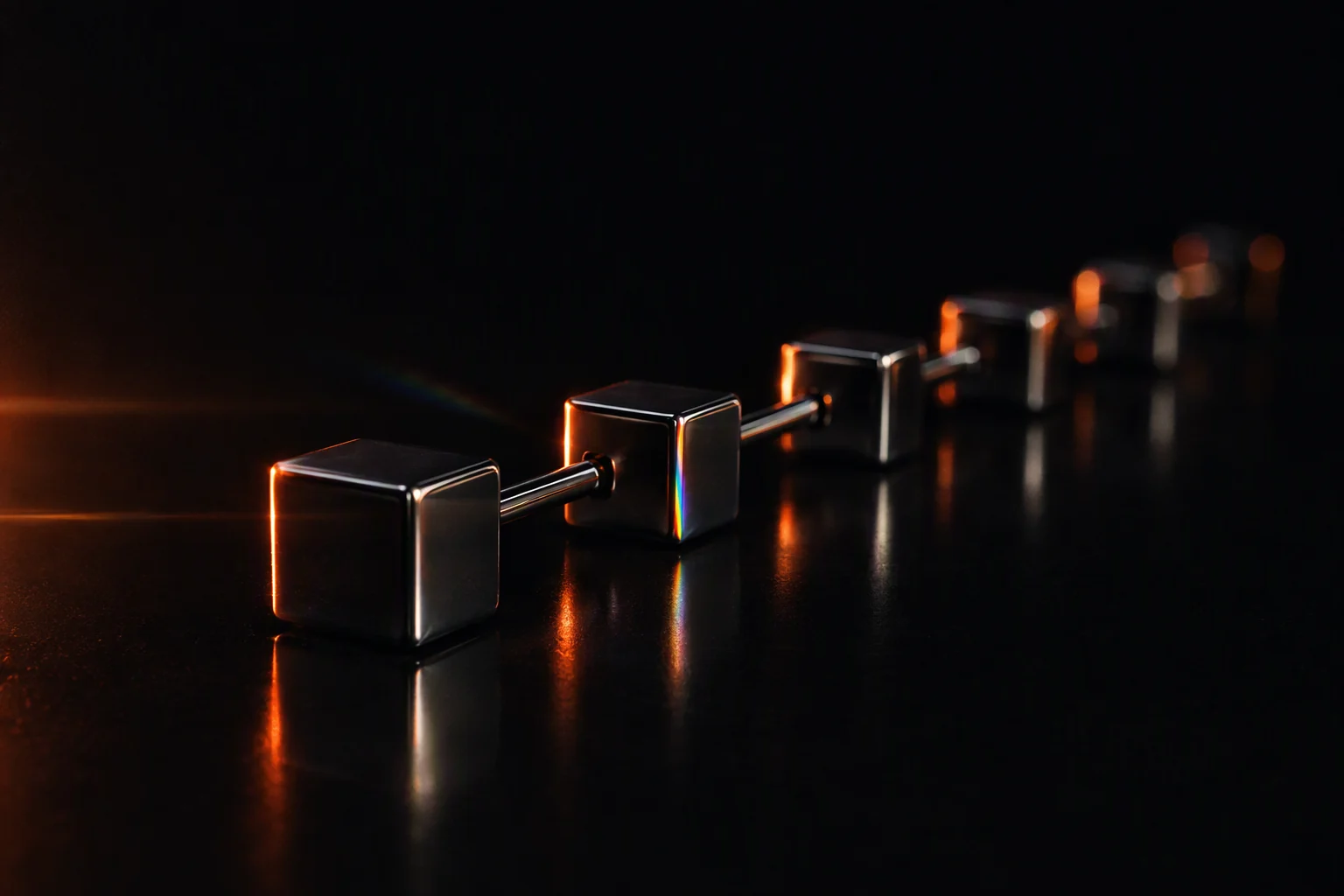 A row of dark chrome cubes joined by metal rods, receding diagonally like a ledger